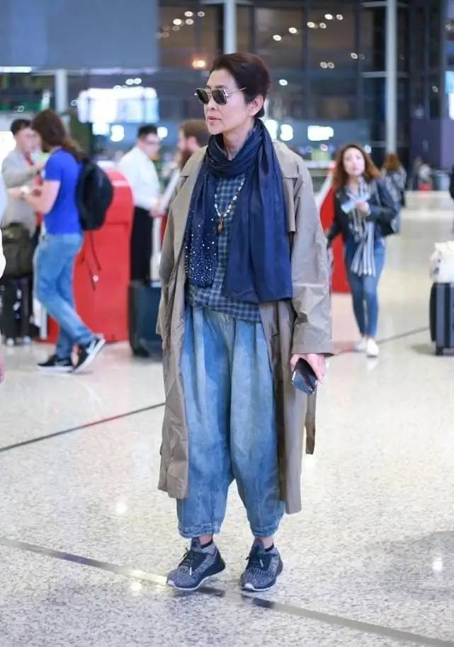 65岁倪萍走机场带火了乞丐风穿搭：风衣+飞鼠裤+围巾，洋气又减龄