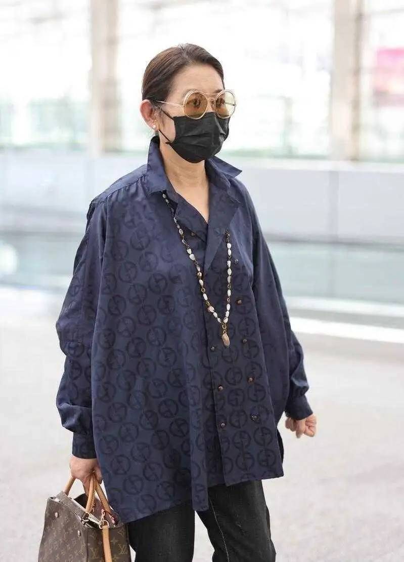 65岁倪萍走机场带火了乞丐风穿搭：风衣+飞鼠裤+围巾，洋气又减龄
